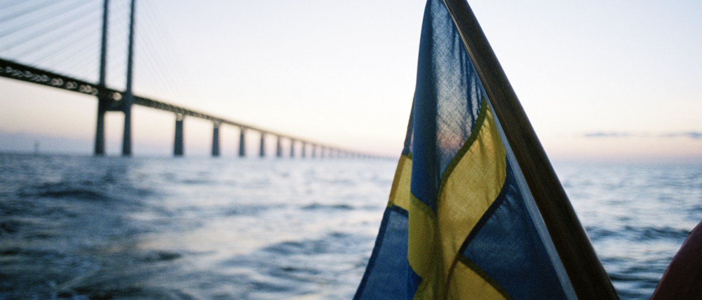 Svensk flagga från båt med Öresundsbron i bakgrunden