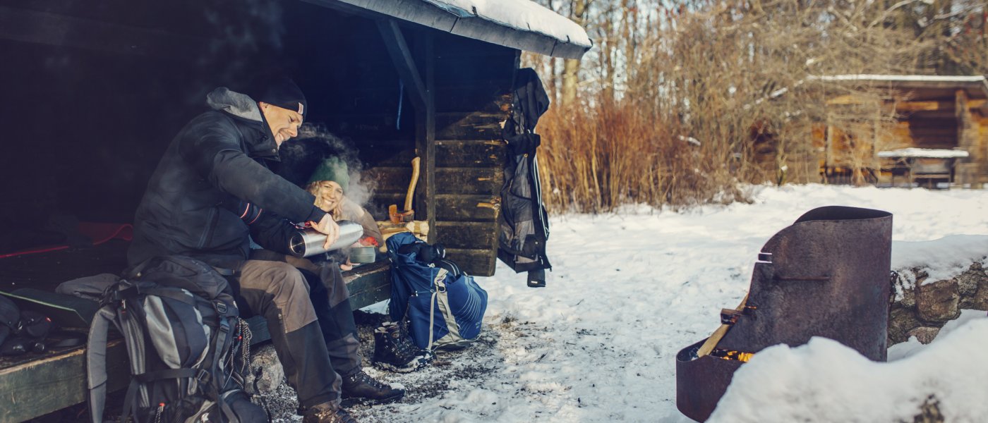 Besökare dricker kaffe i vindskydd en kall vinterdag. Foto.