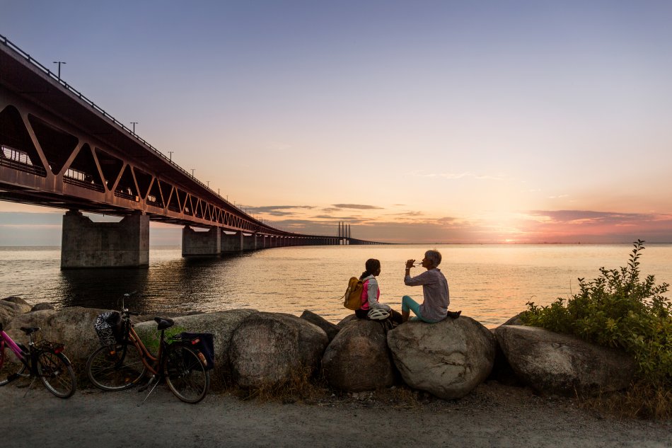Ett par cyklister tar en paus vid Öresundsbrons brofäste. Foto.